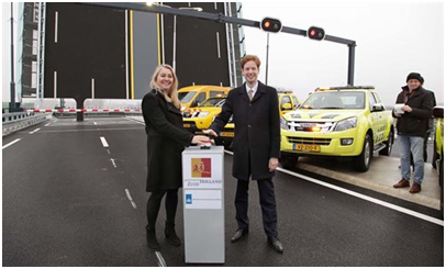 op de foto is minister Schultz te zien die op een knop drukt om het nieuwe wegdeel te openen